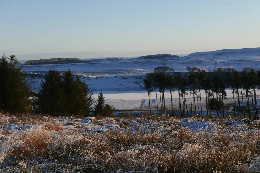 Snow-dusted moorland and a frozen loch in the Scottish Highlands